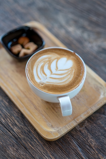 Heißer Kaffee in der Schale mit den Keksen auf Holztisch