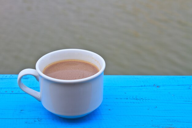 heißer Kaffee in der weißen Schale auf hölzernem