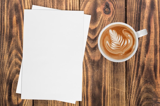 Foto heißer kaffee in tasse mit papieren auf tischhintergrund