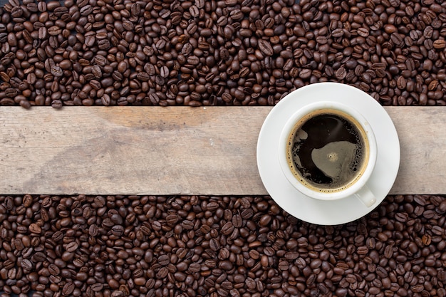 Heißer Kaffee und Bohne auf Holz