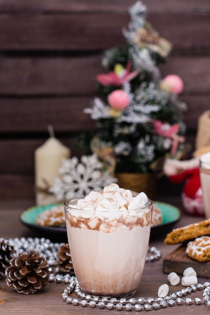 Heißer Kakao mit Eibischen in den Gläsern auf einem Holztisch mit Weihnachtsdekorationen