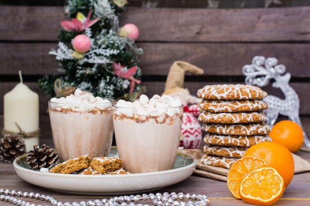 Heißer Kakao mit Eibischen in den Gläsern und Weihnachtsplätzchen in den Weihnachtsdekorationen