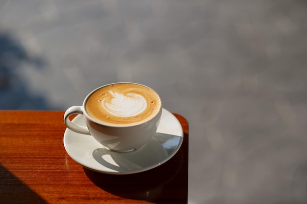 Heißer Latte Art Kaffee auf Holztisch Entspannungszeit