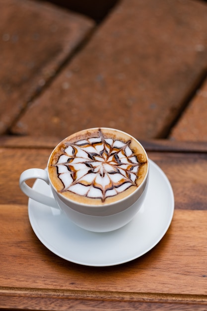 Heißer Latte-Art-Kaffee auf Holztisch, Zeit zum Entspannen