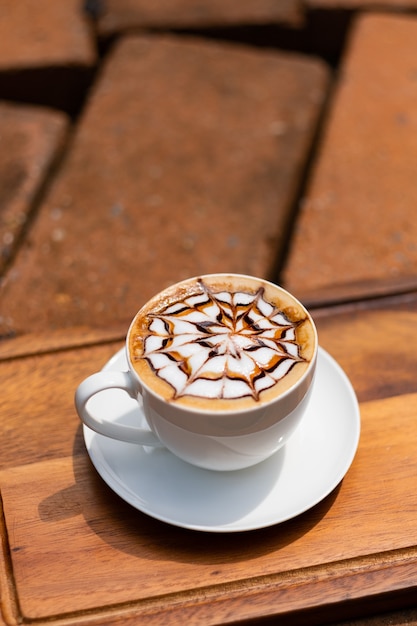 Heißer Latte-Art-Kaffee auf Holztisch, Zeit zum Entspannen