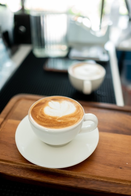 Heißer Latte-Art-Kaffee auf Holztisch, Zeit zum Entspannen