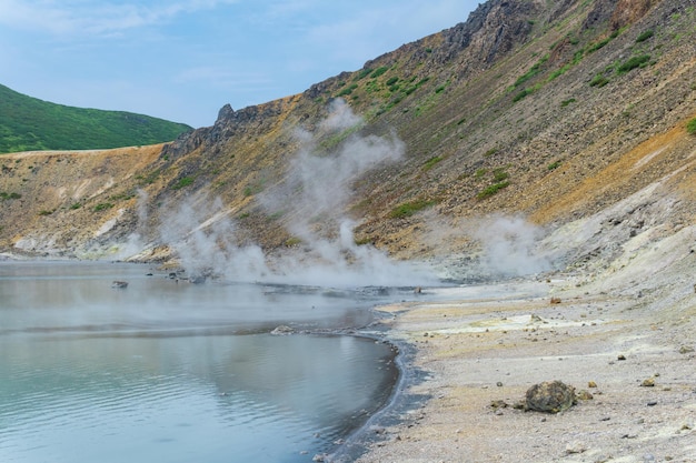 Heißer mineralisierter See mit Thermalquelle und rauchenden Fumarolen in der Caldera des Golovnin-Vulkans auf der Insel Kunaschir