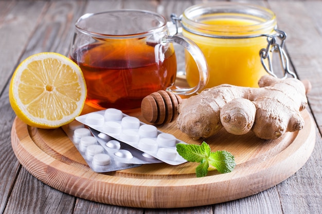 Heißer Tee für Erkältungsmedizin und Honig auf Holztisch
