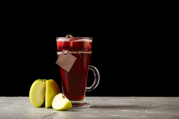 Heißer tee mit apfel in einem glühweinglas