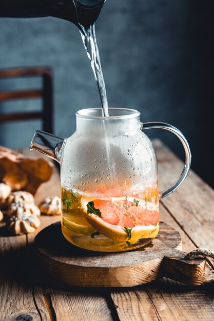 Heißer Tee mit Scheiben frischer Grapefruit auf hölzernem Hintergrund. Gesundes Getränk, Öko, vegan