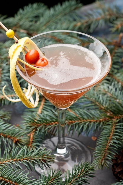 Foto heißer wintercocktail im martiniglas auf tannenzweig