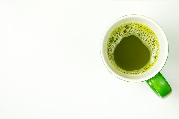 Heißes greentea in der Schale auf weißem Hintergrund. Draufsicht.