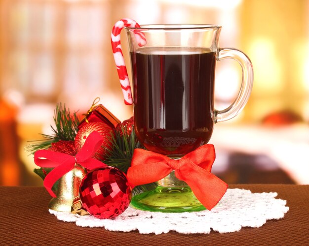 Heißes leckeres Getränk mit Weihnachtssüßigkeiten und anderen Dekorationen auf hellem Hintergrund