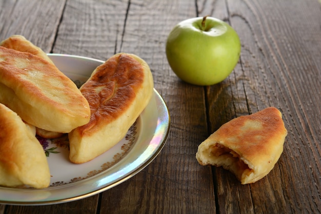 Heißes Patty mit frischen grünen Äpfeln auf Holzhintergrund