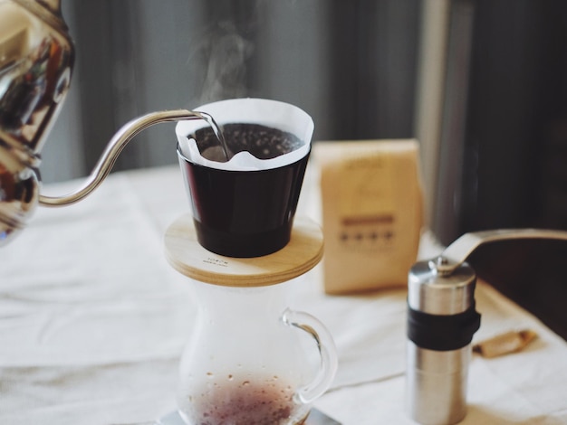Heißes Wasser wird in einen Kaffeefilter auf dem Tisch gegossen