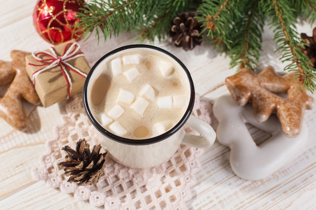 Heißes Weihnachtsgetränk mit Eibischen in einem Eisenbecher und in Lebkuchenplätzchen, auf einer weißen Tabelle. , Urlaub, Exemplar.