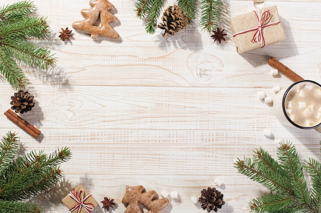 Heißes weihnachtsgetränk mit eibischen in einem eisenbecher und in lebkuchenplätzchen, auf einer weißen tabelle. , urlaub, grußkarte exemplar.