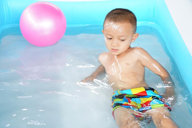 Heißes Wetter Junge spielt gerne mit Wasser in der Wanne