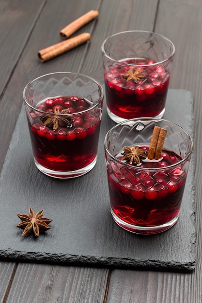 Heißes Wintergetränk mit Preiselbeeren und Gewürzen. Sternanis und Zimtstangen auf dem Tisch. Draufsicht.