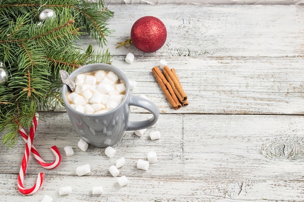 Heißes Wintergetränk. Weihnachtsheiße Schokolade oder -kakao mit Eibisch auf Weiß mit Weihnachtsdekorationen