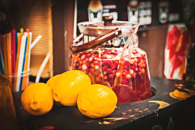 Heißes Wintervitamingetränk aus Zitronen und Preiselbeeren im Glastopf im Straßencafé