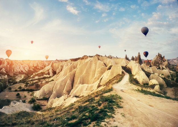 Heißluftballon, der über Felsenlandschaft bei Kappadokien Türkei fliegt.