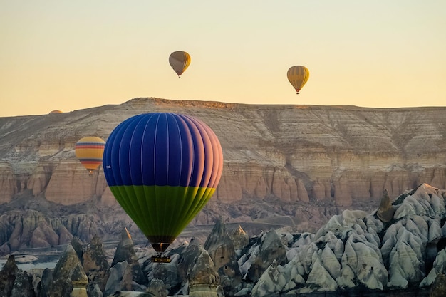 Heißluftballon fliegt über Felslandschaft in Kappadokien Türkei