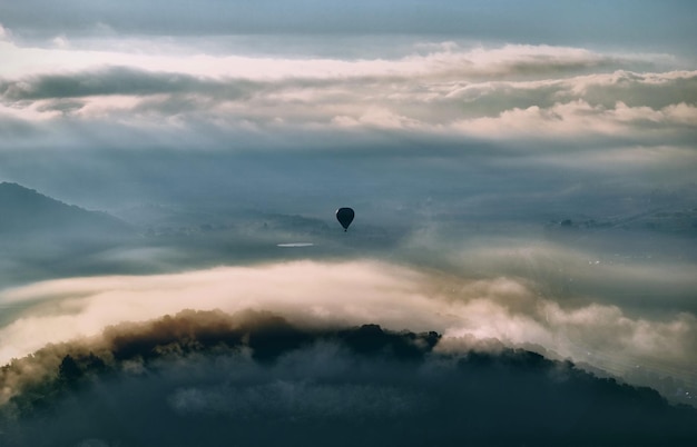 Heißluftballon fliegt über Land gegen den Himmel
