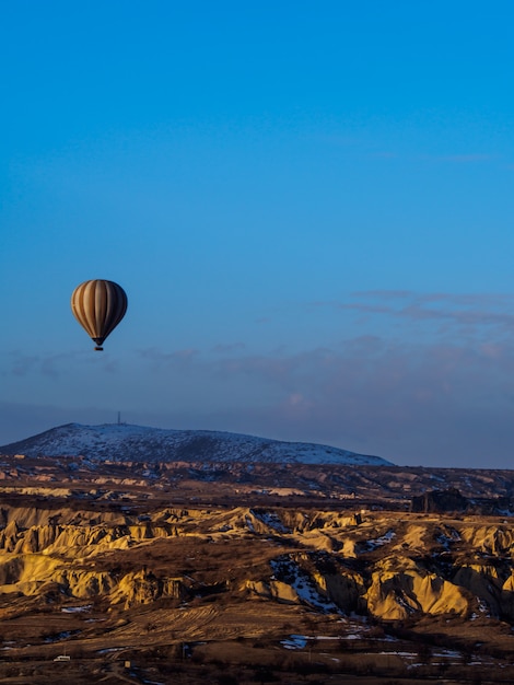 Heißluftballone, die über den Berg in Nationalpark die Türkei Cappadocia Goreme fliegen