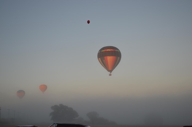 Heißluftballons fliegen bei Sonnenuntergang gegen den Himmel