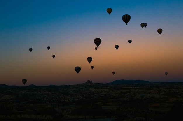 Heißluftballons fliegen bei Sonnenuntergang über Kappadokien