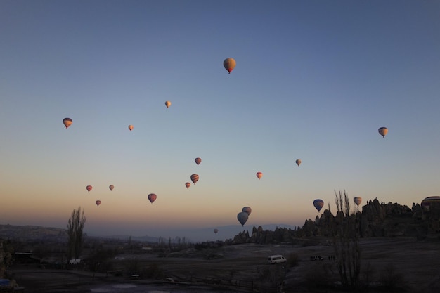 Heißluftballons fliegen über die Landschaft gegen einen klaren Himmel in Kappadokien