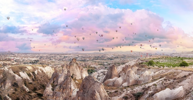 Heißluftballons im rosa Morgenhimmel über Kappadokien. Panorama. Göreme, Türkei