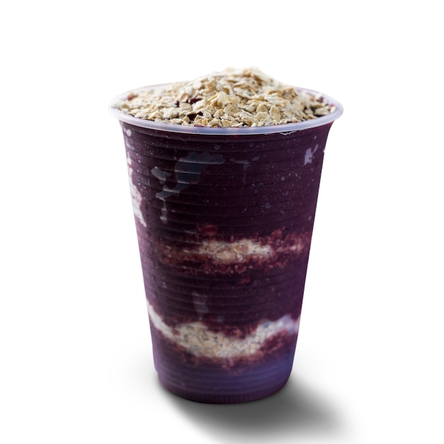 Helado brasileño de bayas de acai congelado en un vaso de plástico con copos de avena. aislado sobre fondo blanco. Vista frontal del menú de verano