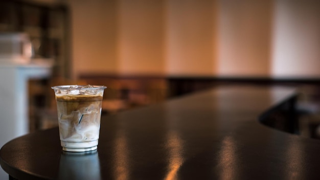 Helado de café en un vaso de plástico con crema que se vierte en él mostrando la textura