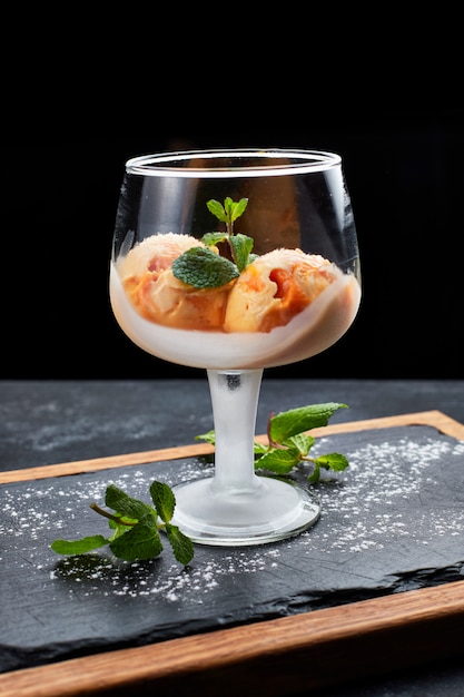 Helado de calabaza en una copa de cristal con una tabla de madera