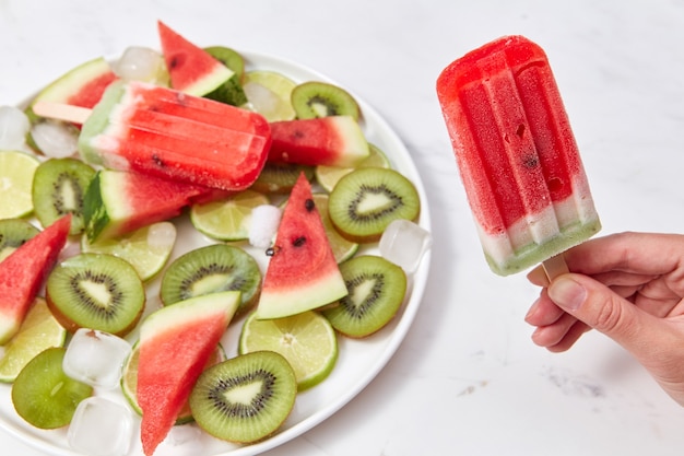 Helado casero en un palito con un trozo de frutas