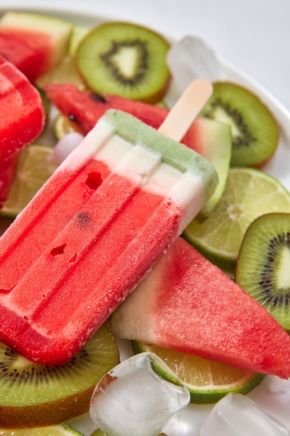 Helado casero en un palito con un trozo de frutas