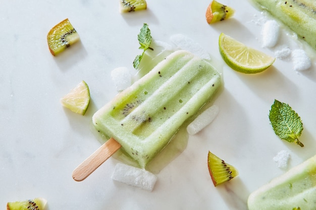 Helado casero en un palito con un trozo de frutas