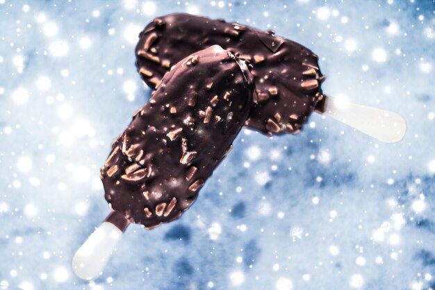 Foto helado de chocolate y almendras sobre una mesa de mármol con nieve brillante fondo de comida de vacaciones de invierno