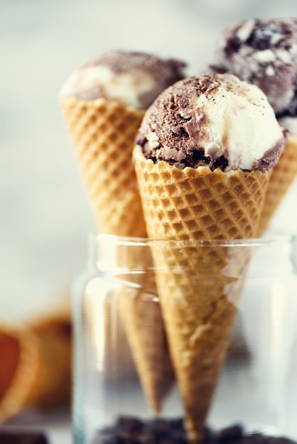 Helado de chocolate y café en cono de waffle con granos de café sobre piedra gris