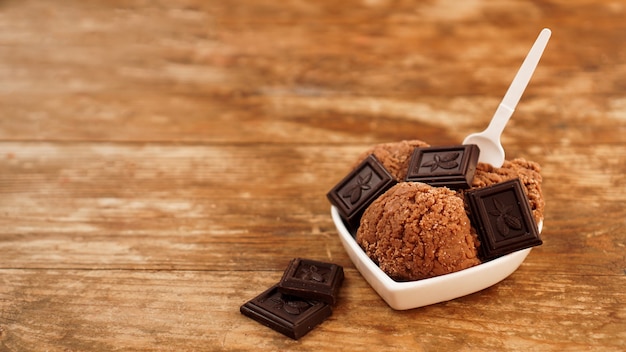 Helado de chocolate casero con trozos de chocolate en un recipiente blanco