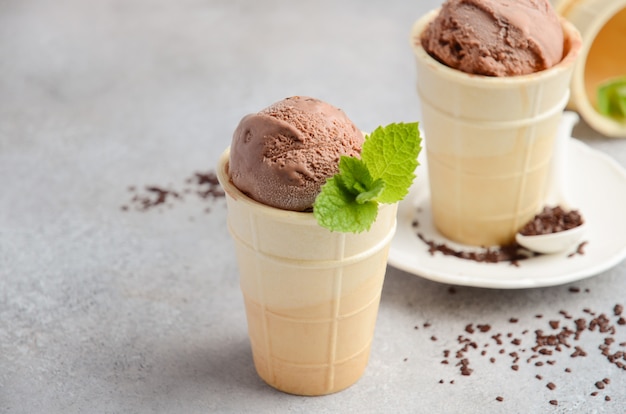 Helado de chocolate en cono de waffle sobre un fondo de hormigón gris