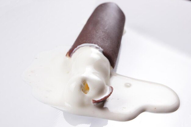 Helado de chocolate en un palo aislado sobre fondo blanco. Primer plano de helado cubierto de chocolate
