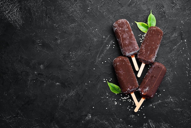 Helado de chocolate en un palo Sobre un fondo negro Vista superior Espacio de copia libre