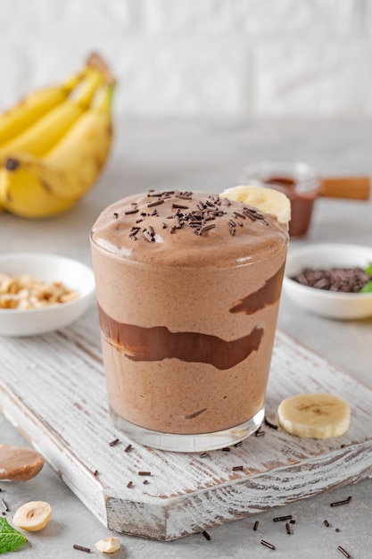 Helado de chocolate de plátano vegano con glaseado de chocolate y chispas en un vaso Comida saludable