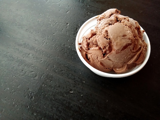 Helado de chocolate en la taza con fondo negro