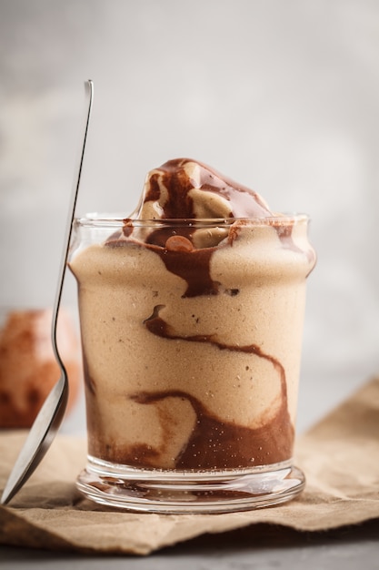 Foto helado de chocolate del vegano en un tarro de cristal. postre saludable fondo gris