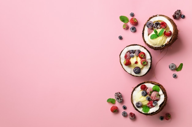 Helado de coco con bayas frescas en mitades de cocos. Comida en estilo minimalista.