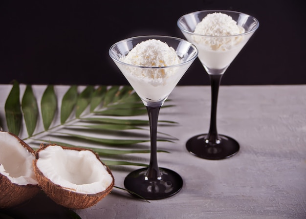 Helado de coco en el fondo gris con hoja de palma y coco